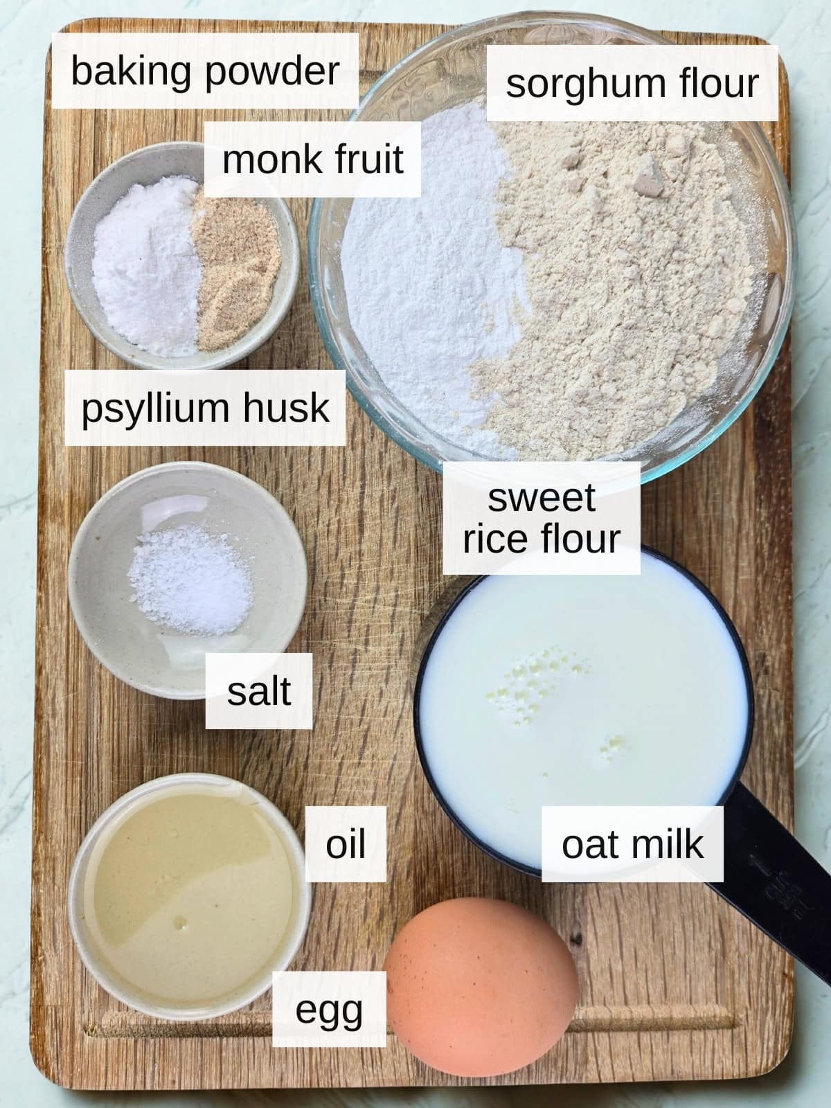 Ingredients for gluten-free waffles, including baking powder, monk fruit powder, sorghum flour, psyllium husk, sweet rice flour, salt, oil, egg, and oat milk.