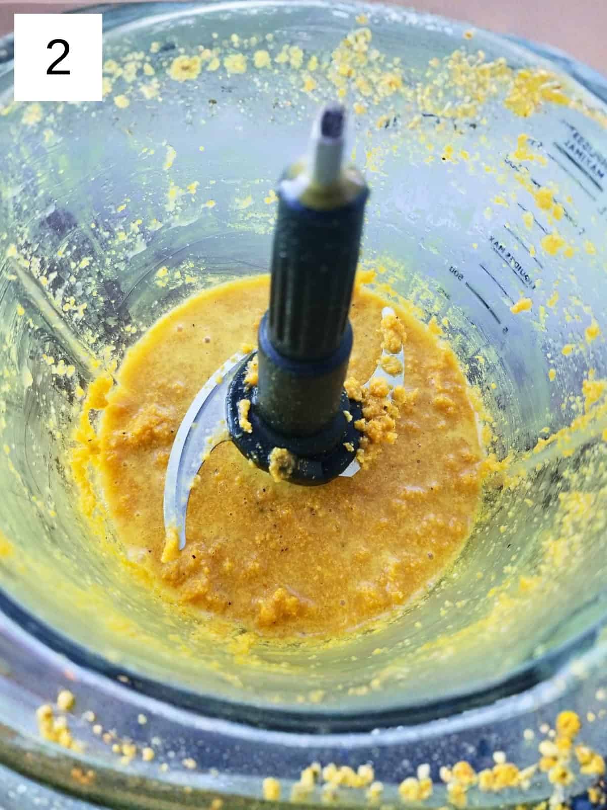 Step 2 for making ginger turmeric shots, showing the blending process of ginger and turmeric for a health-boosting shot.