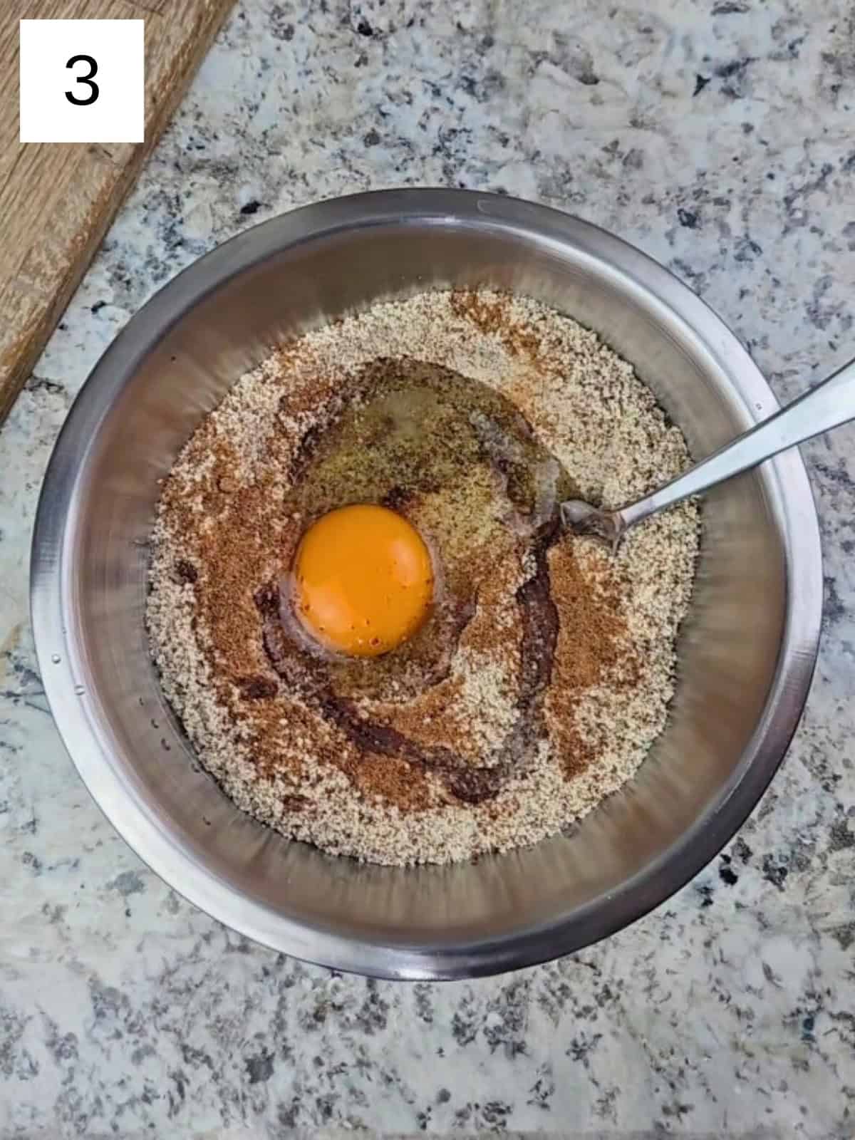 A mixture of all the dry ingredients for vanilla almond cookies, along with an egg and oil.