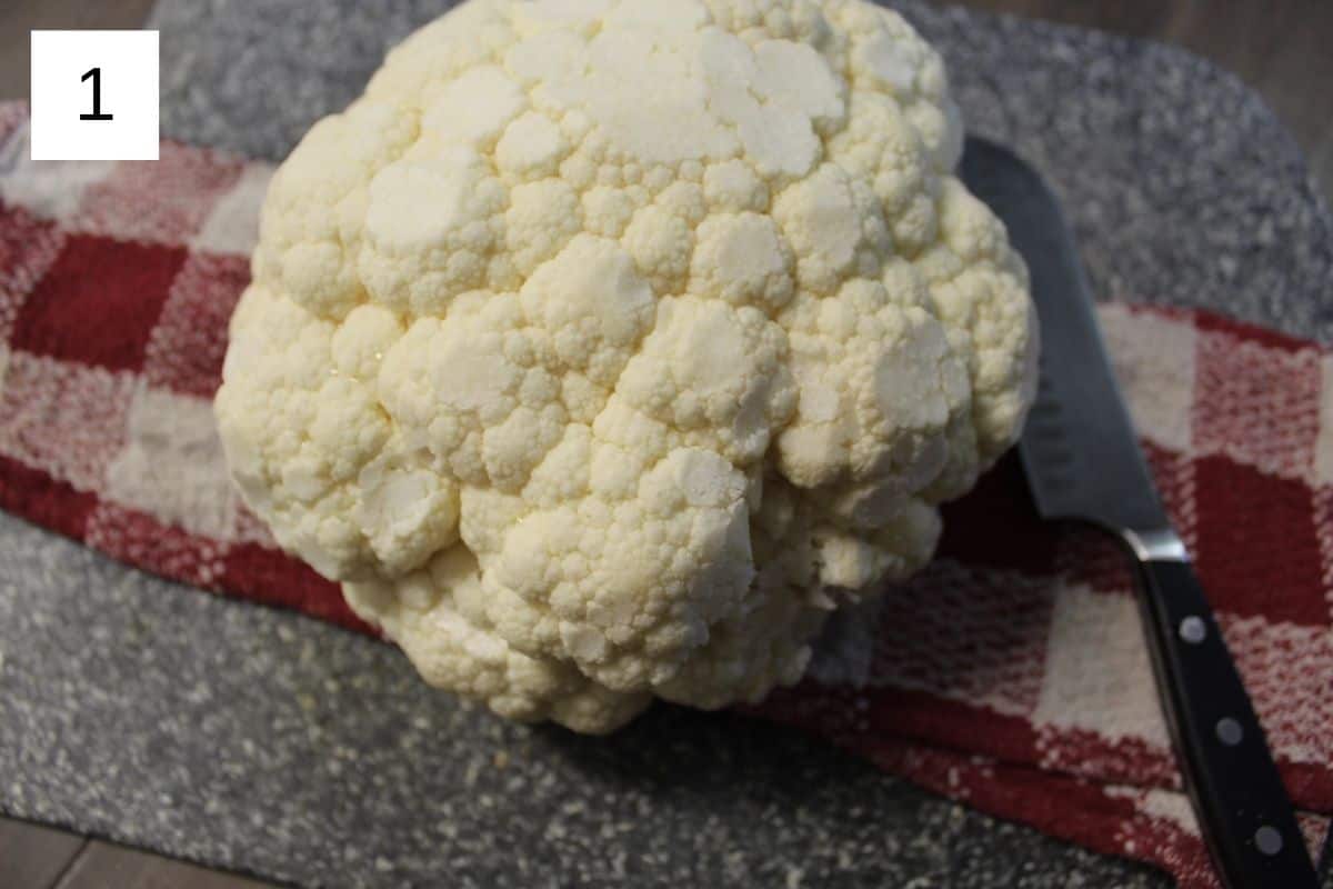 one large head of cauliflower on a flat surface.