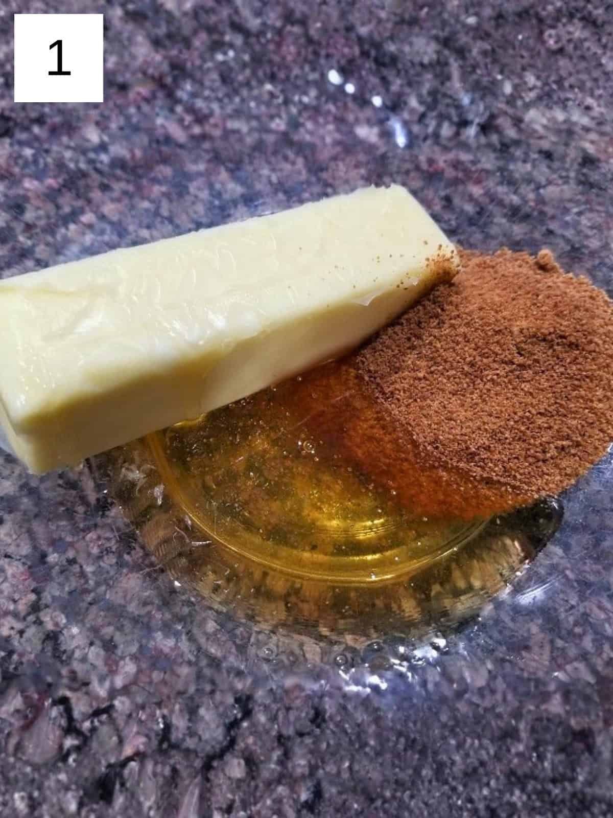 A half stick of unsalted butter, coconut sugar, and honey in a glass mixing bowl.