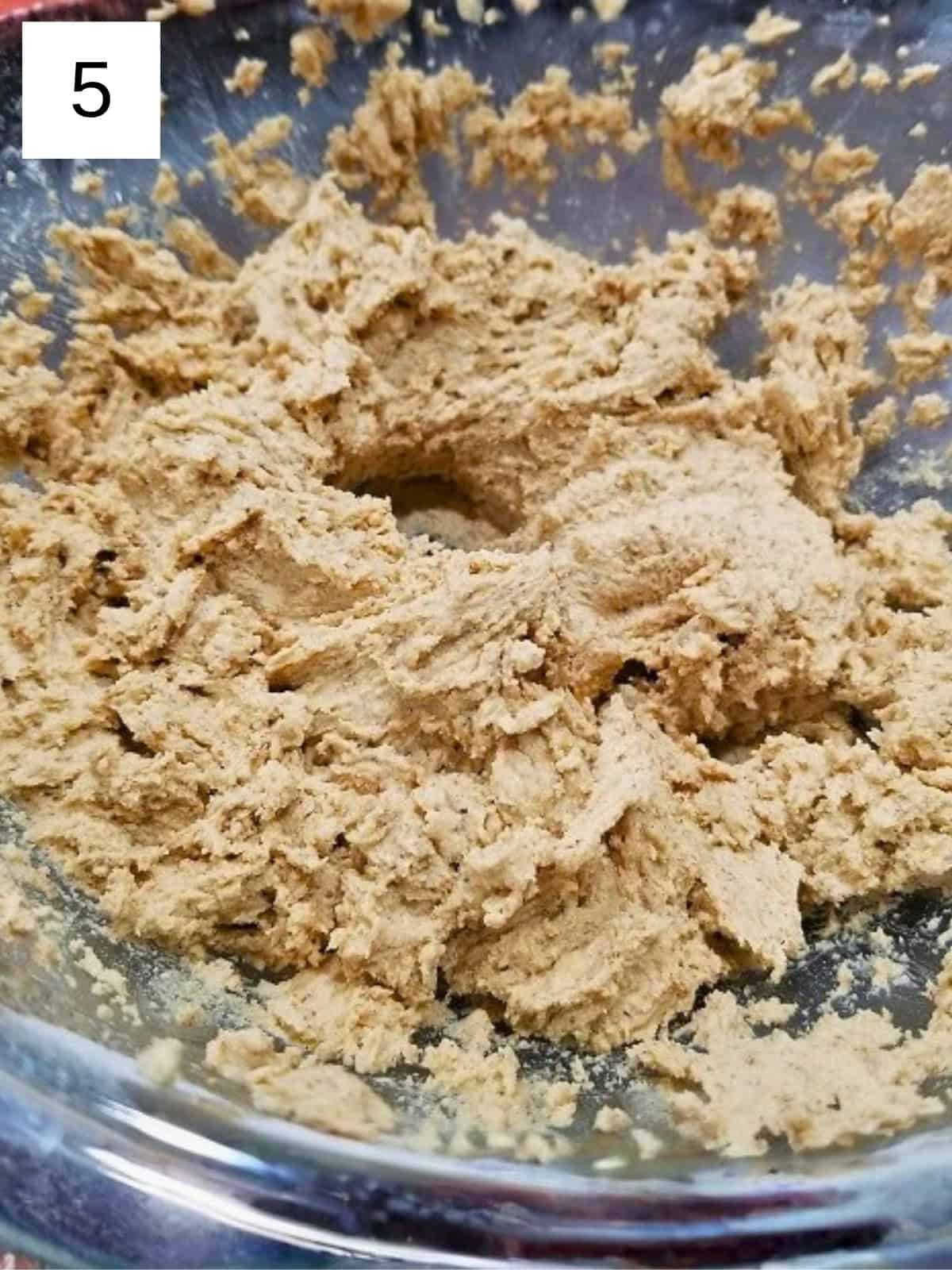 A mixture of cookie dough in a mixing bowl.