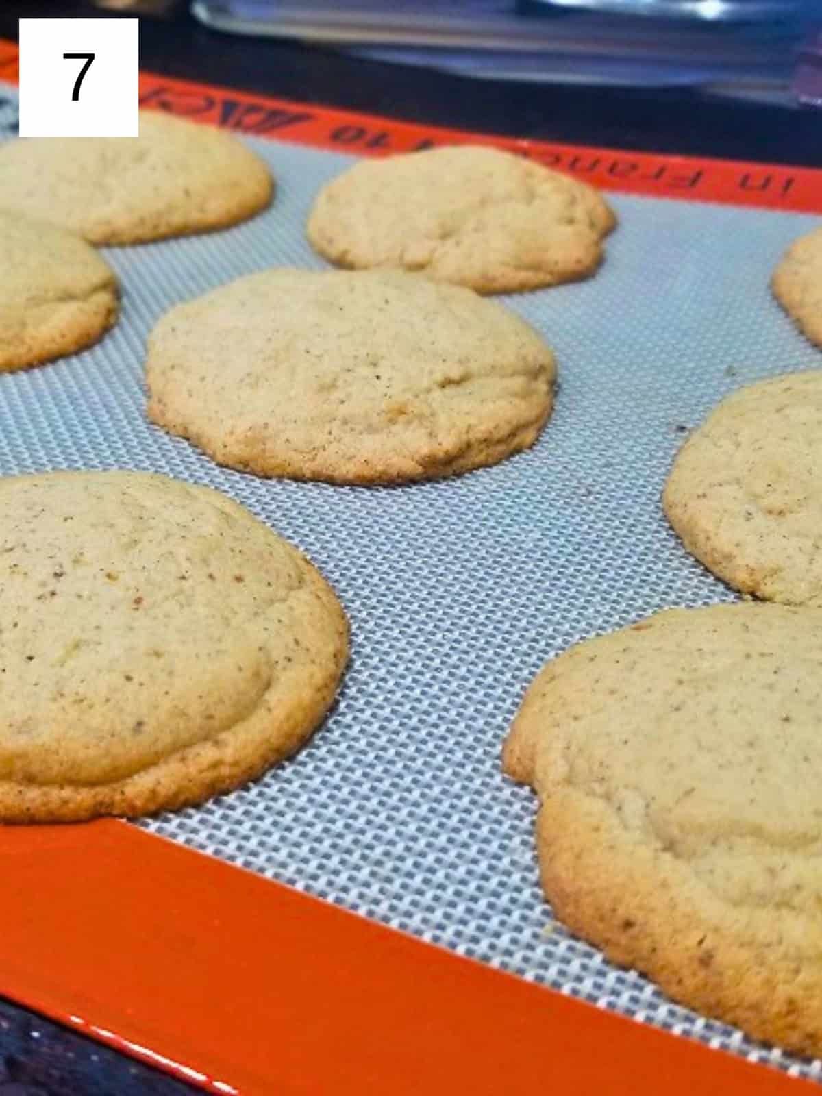 Freshly baked honey cardamom cookies in a parchment-lined baking tray.