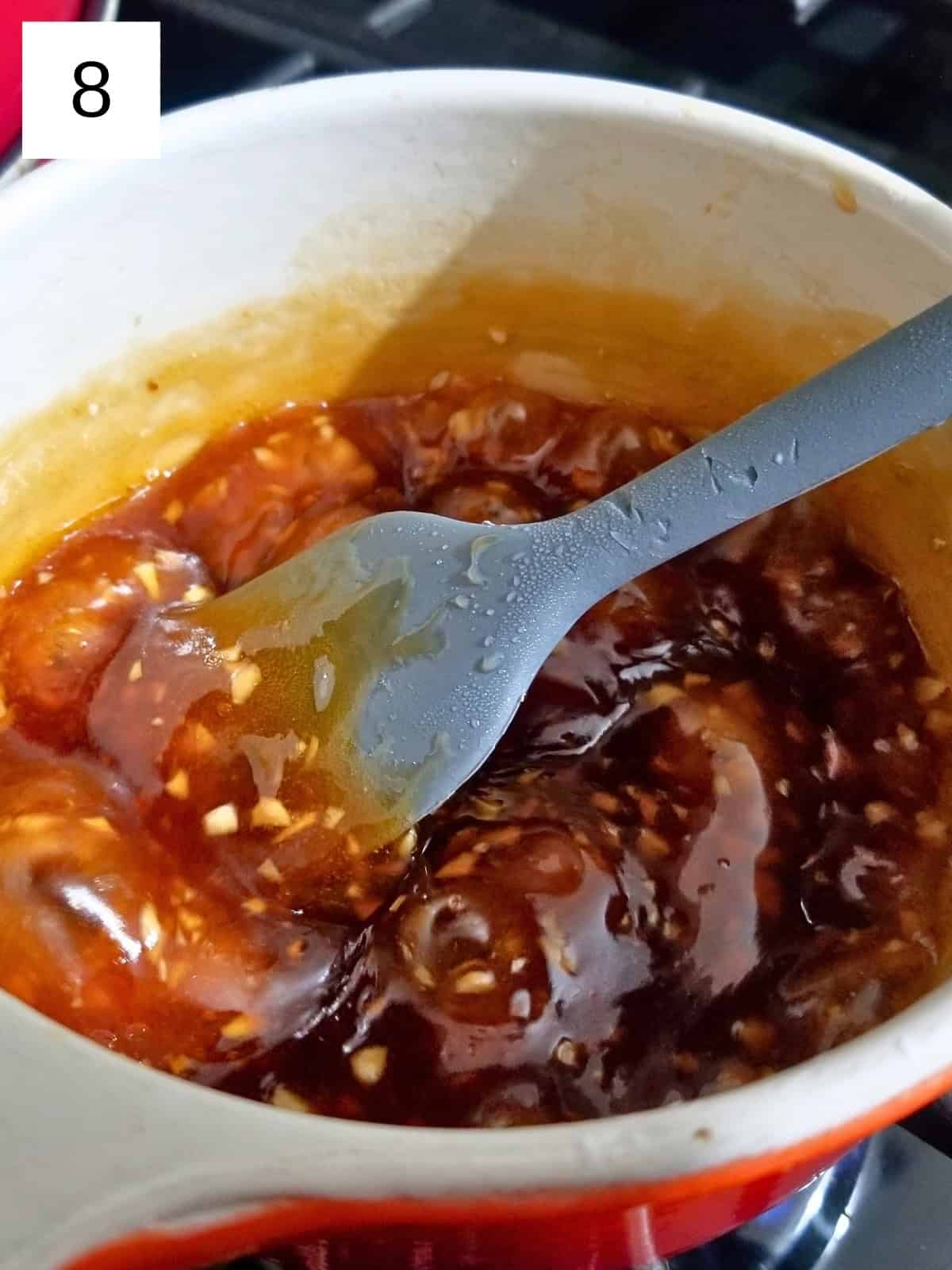 A mixture of honey, minced garlic, water, tapioca starch, vinegar, and coconut aminos in a saucepan.