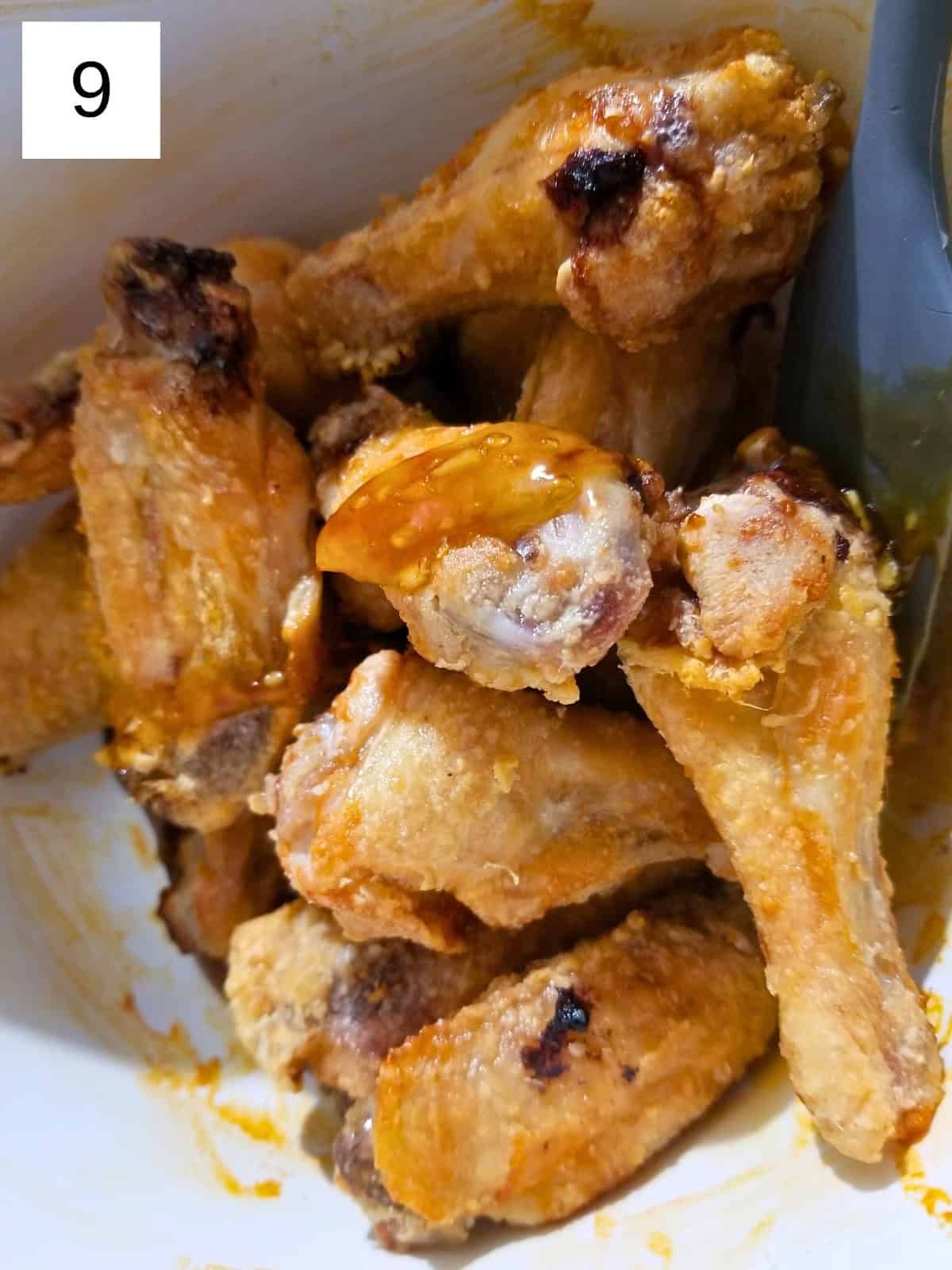 Chicken wings, coated with honey garlic sauce, in a bowl.