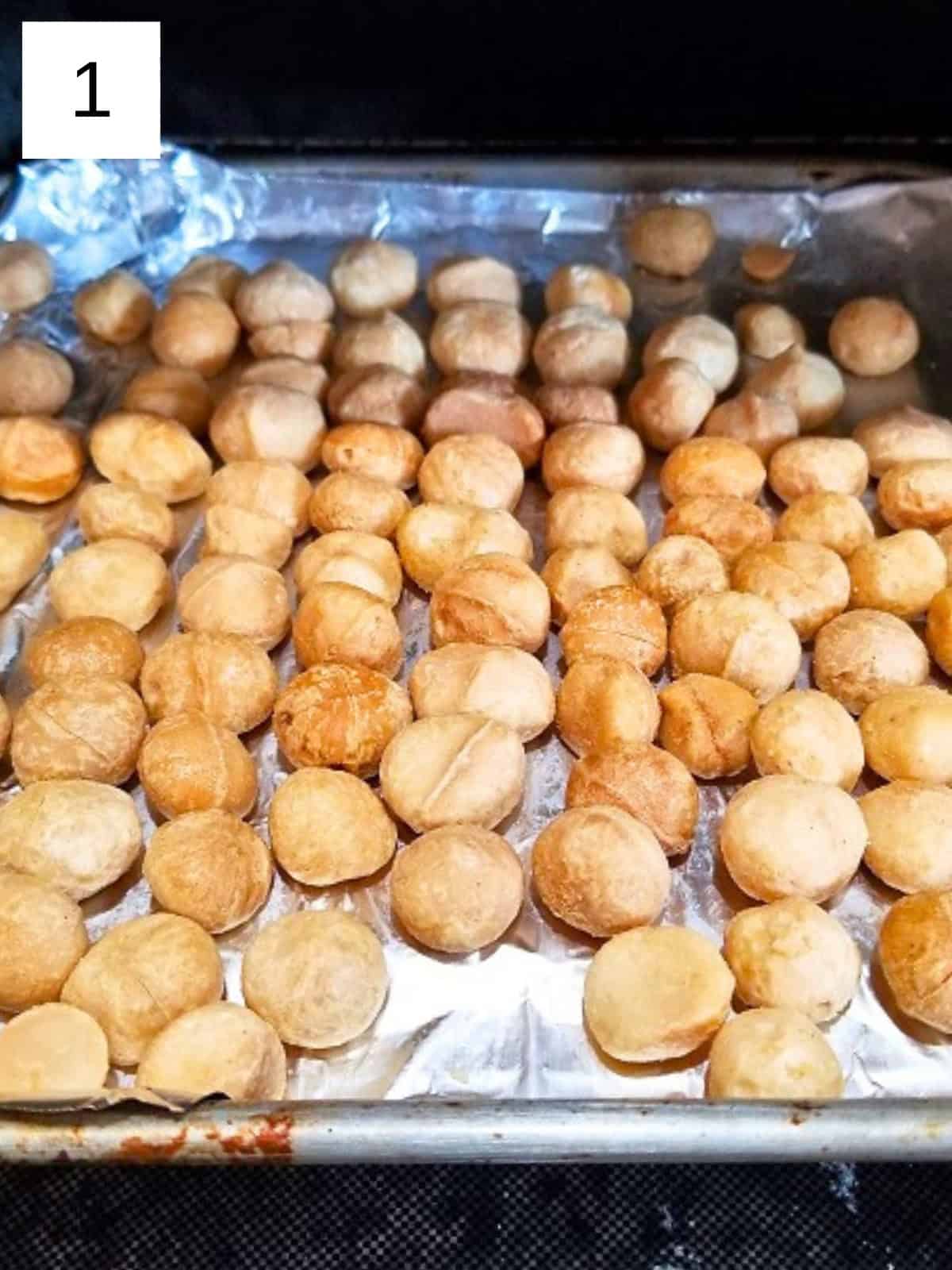 macadamia nuts in a foil-wrapped baking tray.