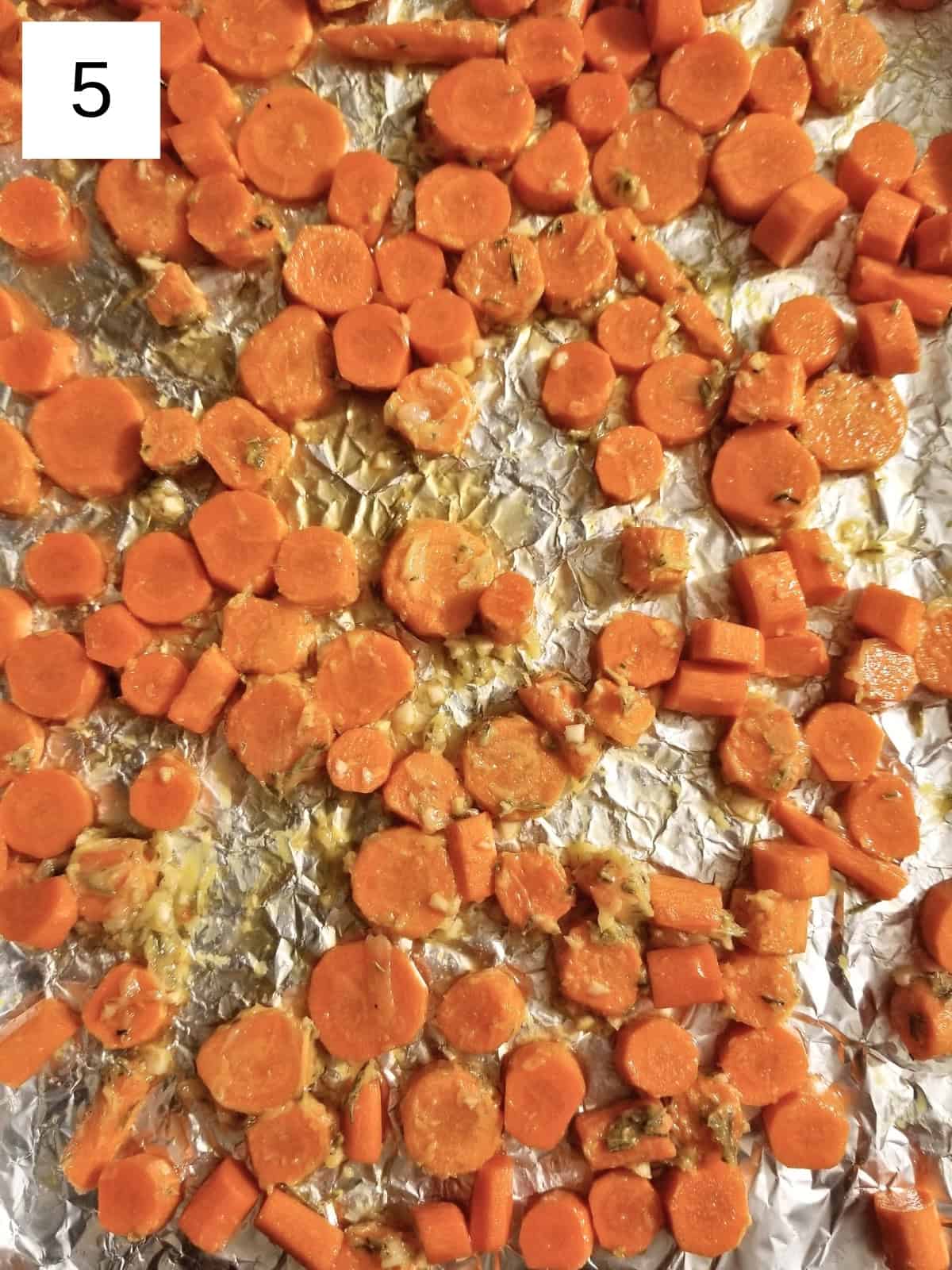 seasoned carrots on a foil-wrapped baking tray.