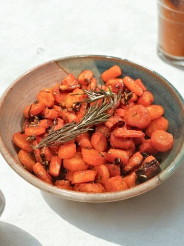 baked garlic and rosemary carrots with maple glaze in a bowl.