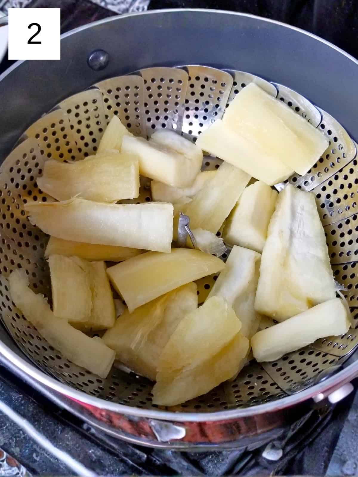 Defrosted yuca fries resting in a steamer basket set inside a pot.