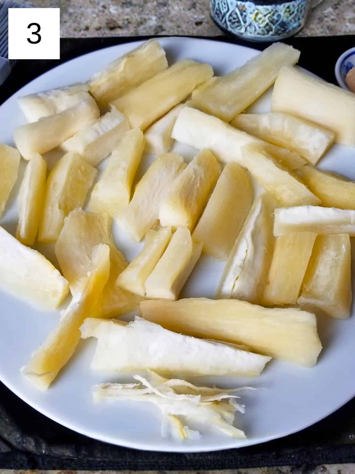 Yuca fries on a plate, ready to be seasoned before air frying.