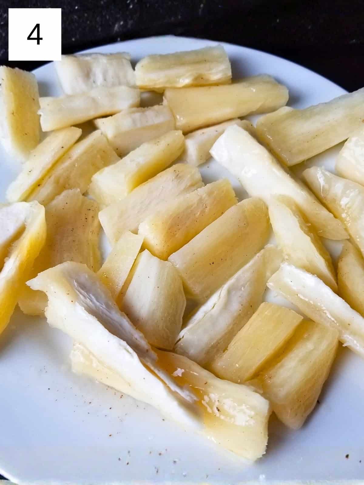 Yuca fries on a plate, ready to be seasoned before air frying.