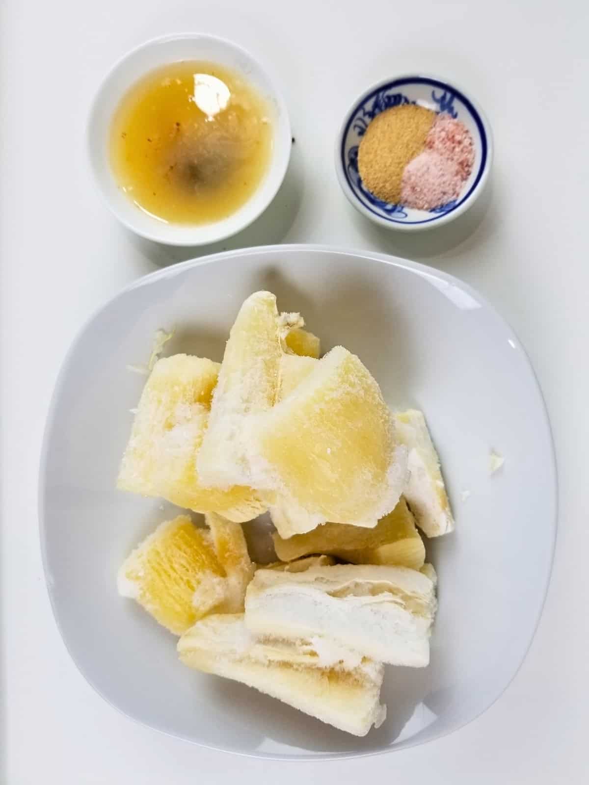 Ingredients for air fryer yuca fries, including oil, garlic powder, sea salt, and frozen yuca fries.