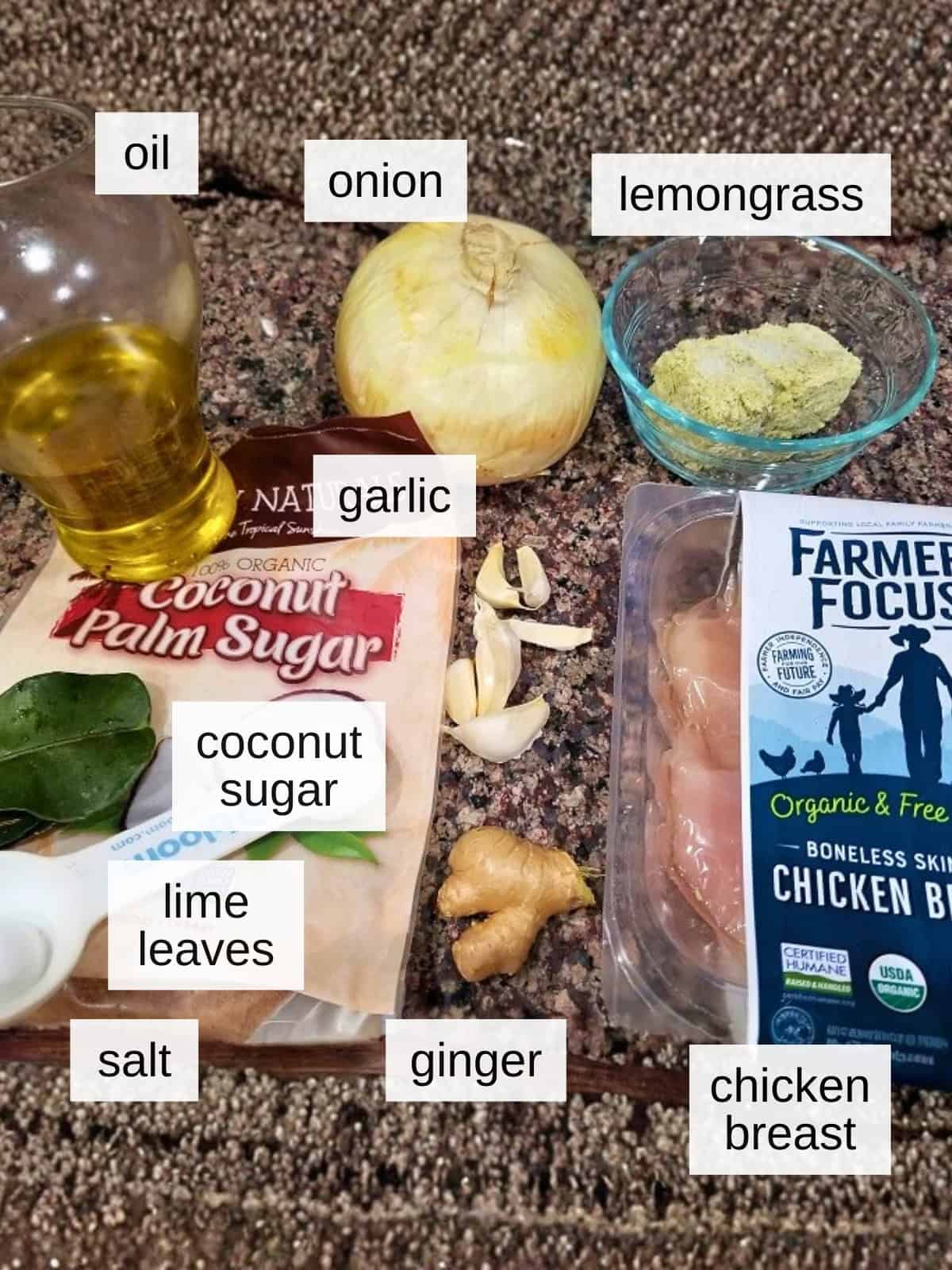 Ingredients for lemongrass chicken, including oil, onion, frozen lemongrass, garlic, coconut sugar, lime leaves, salt, ginger, and chicken breast.