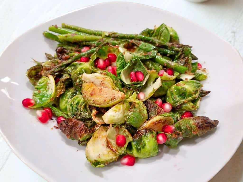 A plate of quick roasted asparagus and Brussels sprouts showcasing a simple and flavorful recipe.