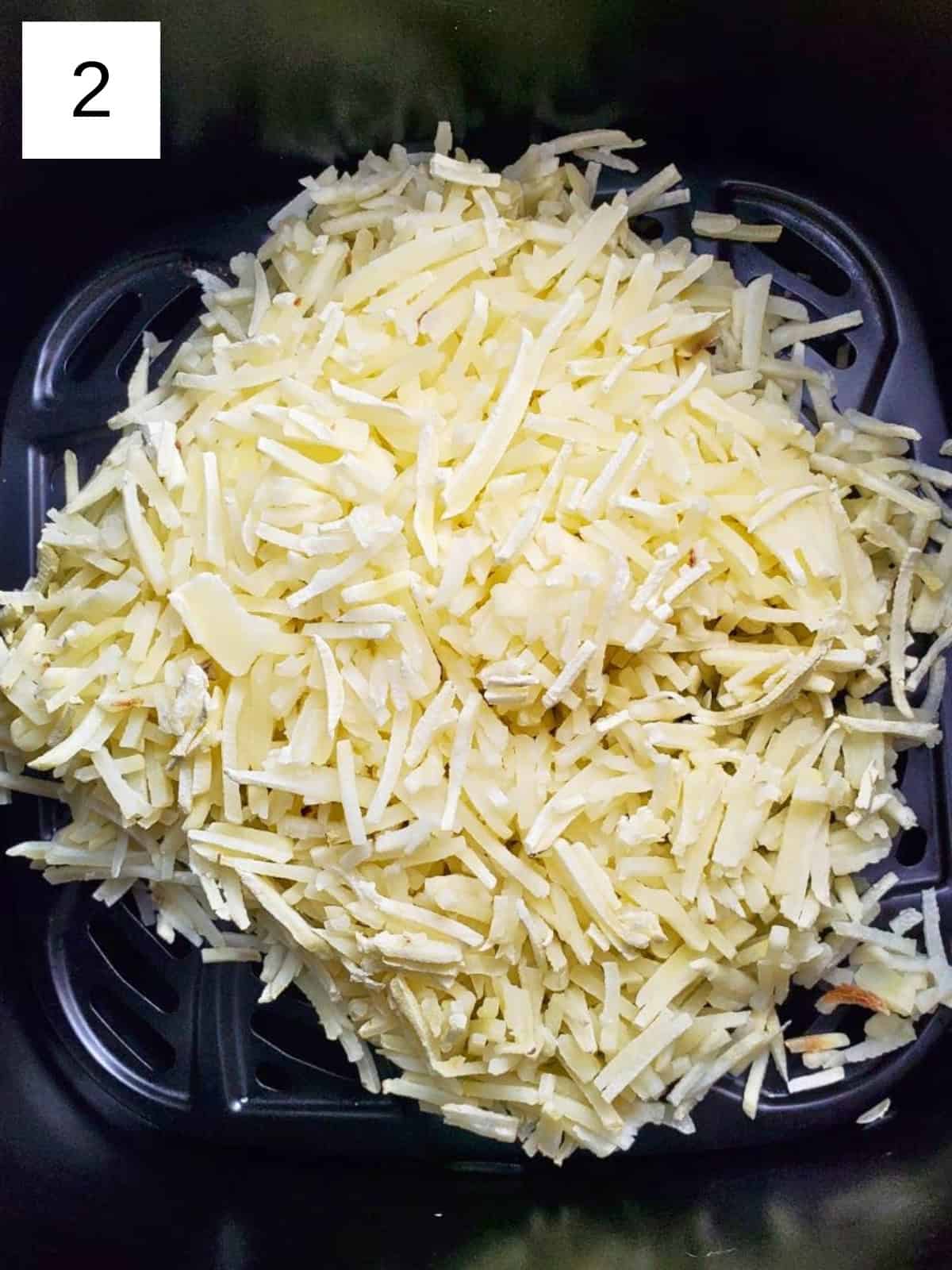 Frozen hashbrowns inside an air fryer.