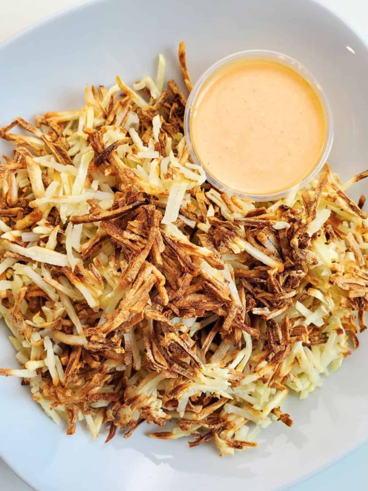 Air fried shredded hashbrowns on a plate.