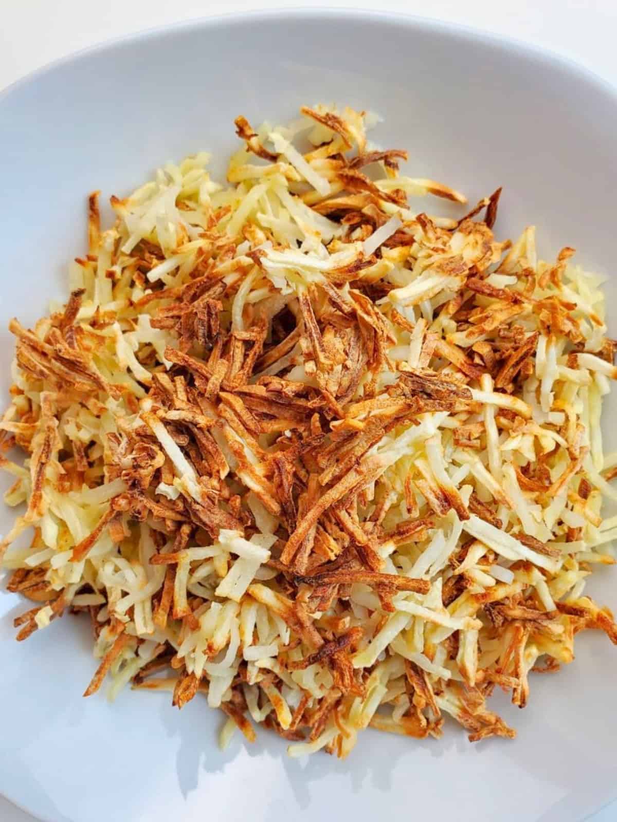 Air fried shredded hashbrowns on a plate.