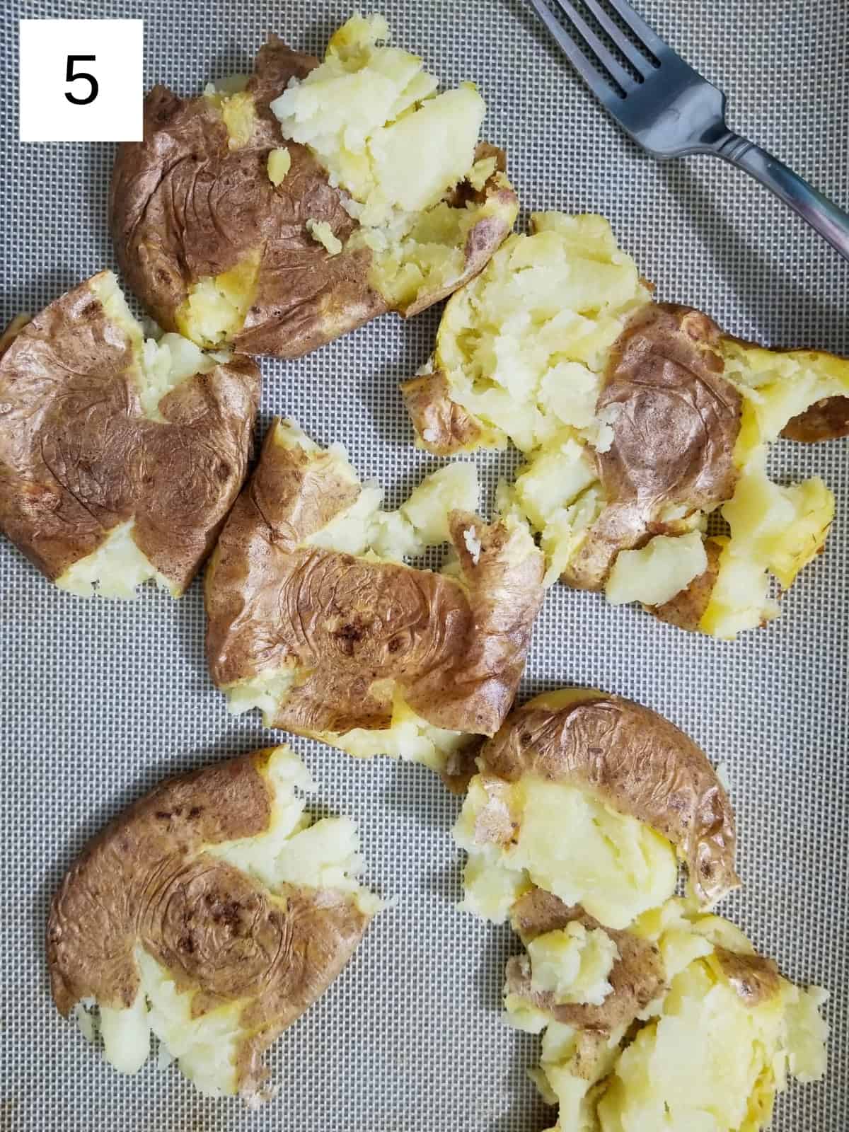 Smashed potatoes on a flat surface.