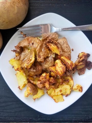 Air fried garlic smashed potatoes on a plate.