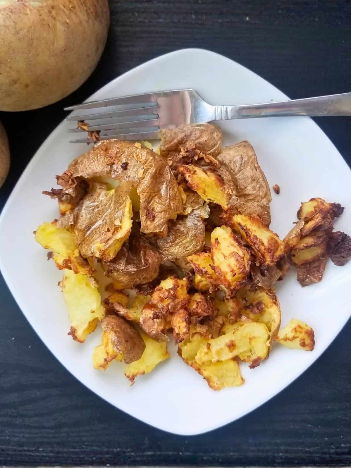Air fried garlic smashed potatoes on a plate.