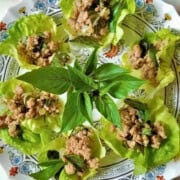 Lettuce wraps made with ground chicken, fresh herbs, garlic, and ginger, on a plate.